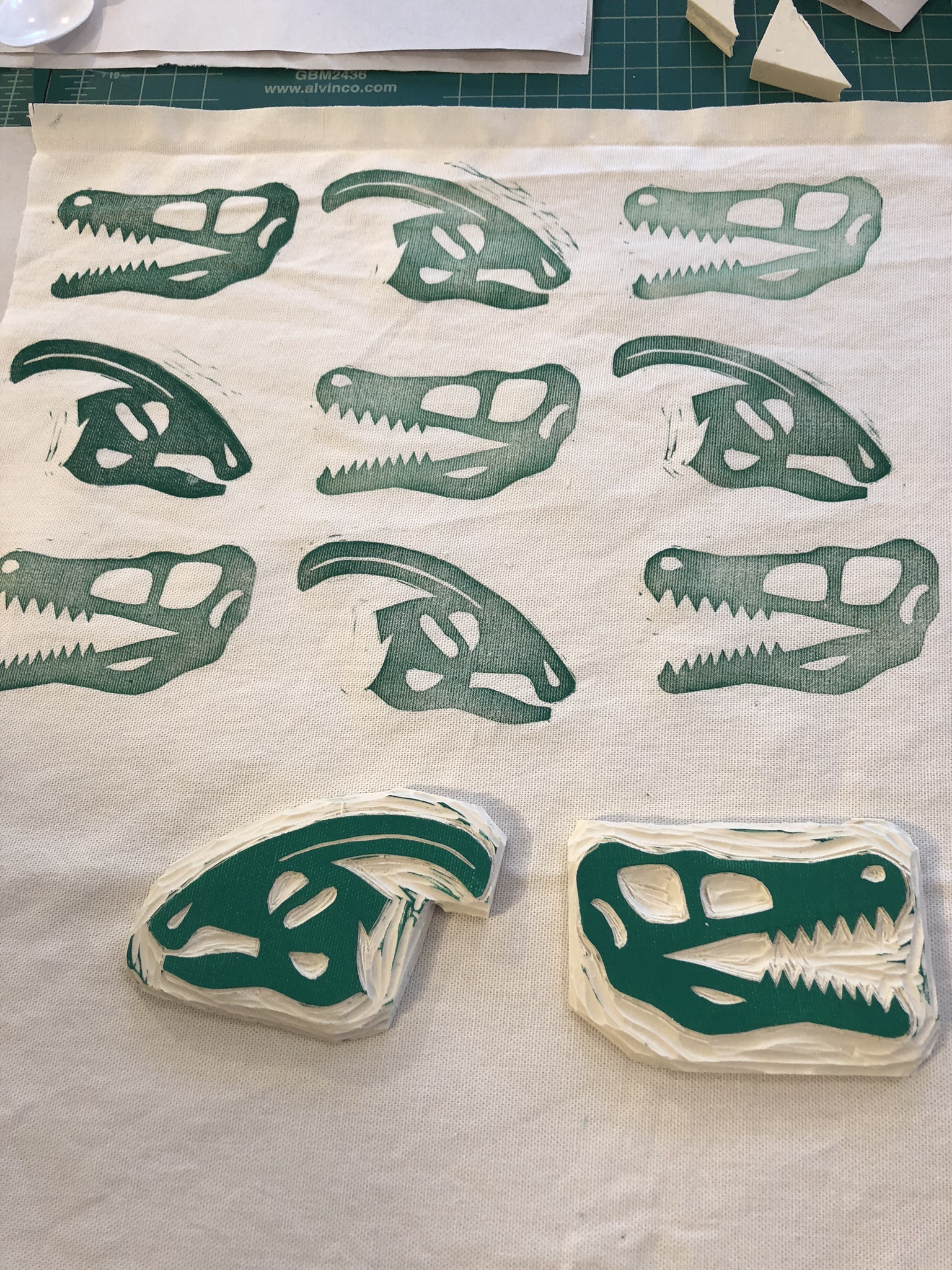 Hand-carved stamps of dinosaur skulls and the fabric they have printed.