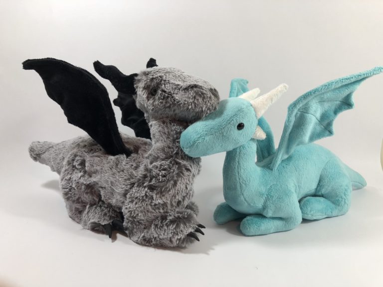 Photo of gray furry plush dragon and teal minky plush dragon rubbing noses.