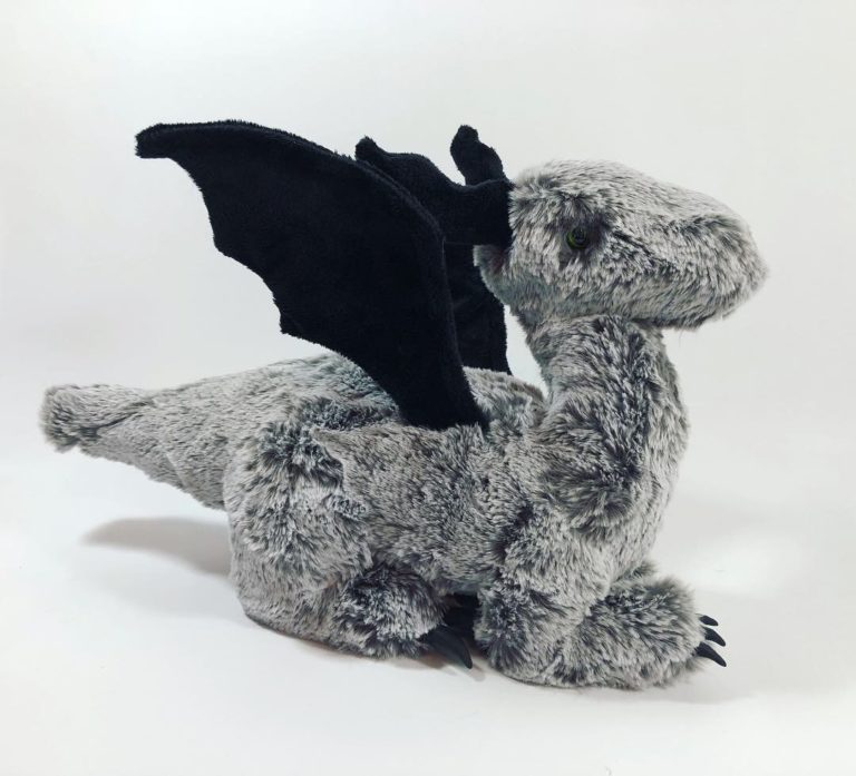 Dragon plush made of gray faux fur with black horns and wings.