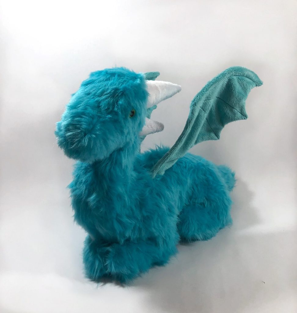 Teal, furry lush dragon seen from 3/4 view.