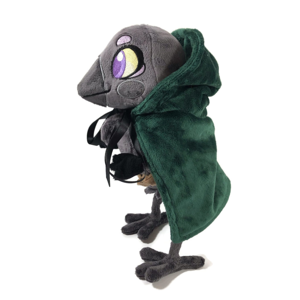 plush gray anthropomorphic crow with embroidered eyes and a green cloak