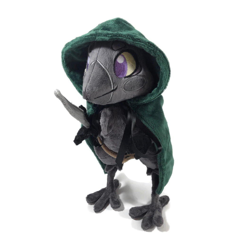 plush gray anthropomorphic crow with embroidered eyes and a green cloak, holding a fabric dagger
